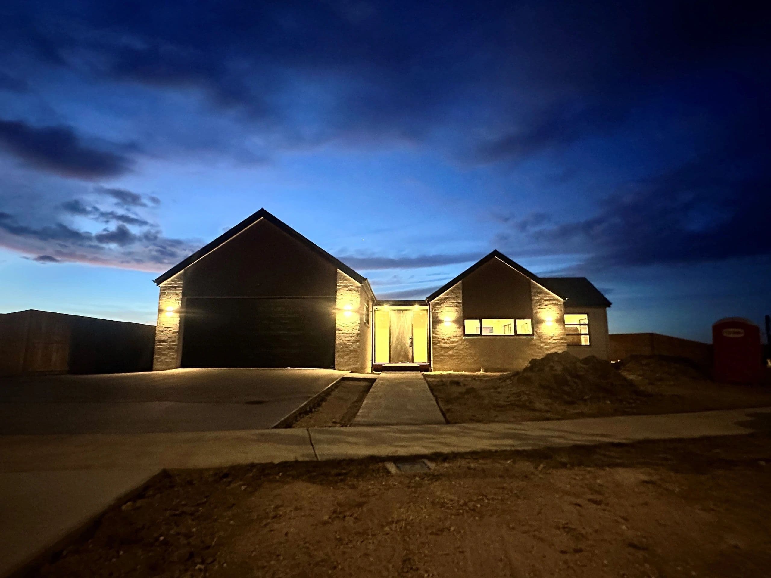 New build home at dusk with exterior and interior lighting by Tronic Electrical